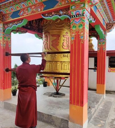 Monk in Tawang Monastery using prayer wheel