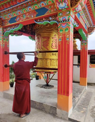 Monk in Tawang Monastery using prayer wheel