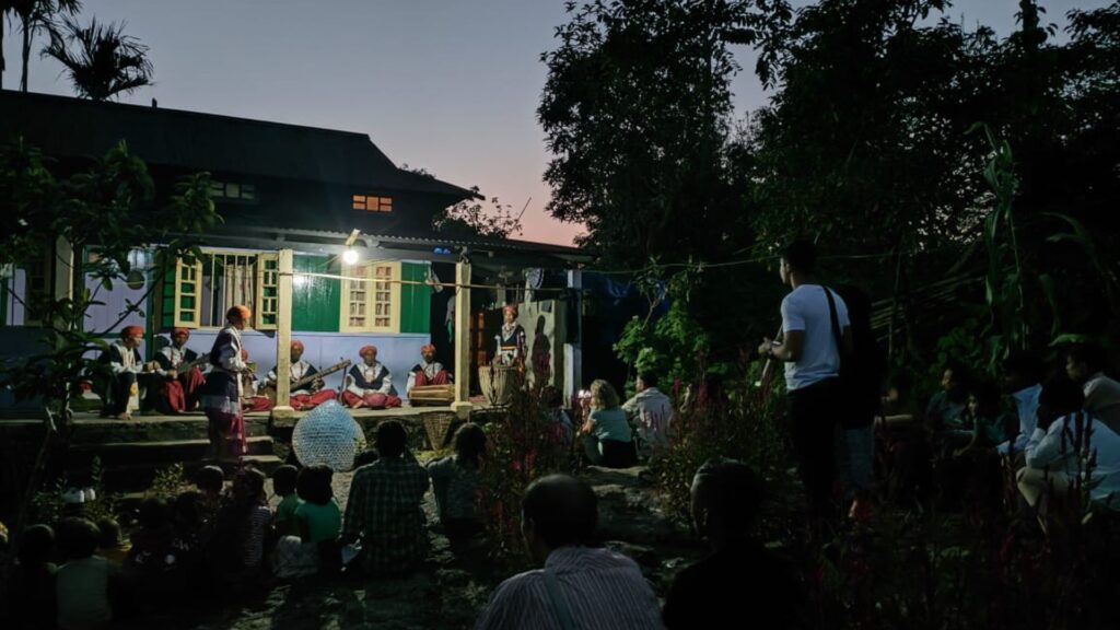 Traditional Khasi musicians performing indoors by fire.