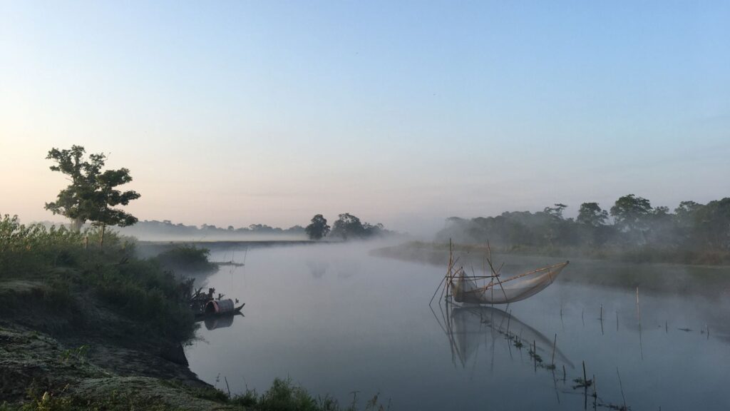 Mist rising over river with bamboo fishing nets at dawn.