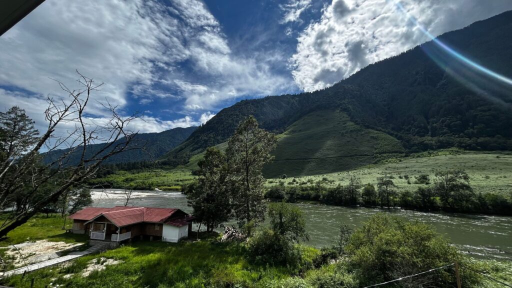 Scenic landscape of Anini with a river flowing past green mountains.