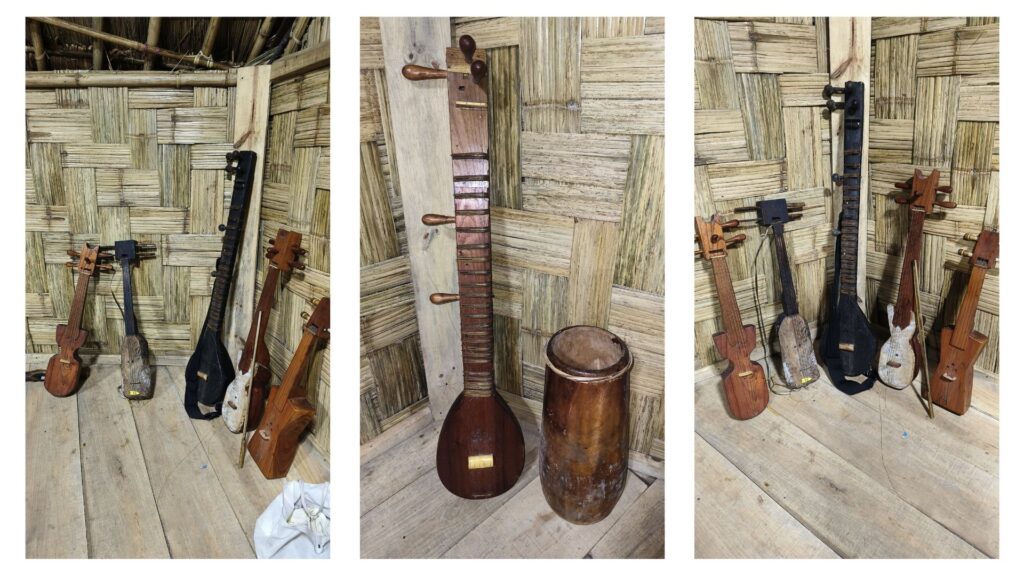 Traditional Khasi string instruments resting against bamboo wall.