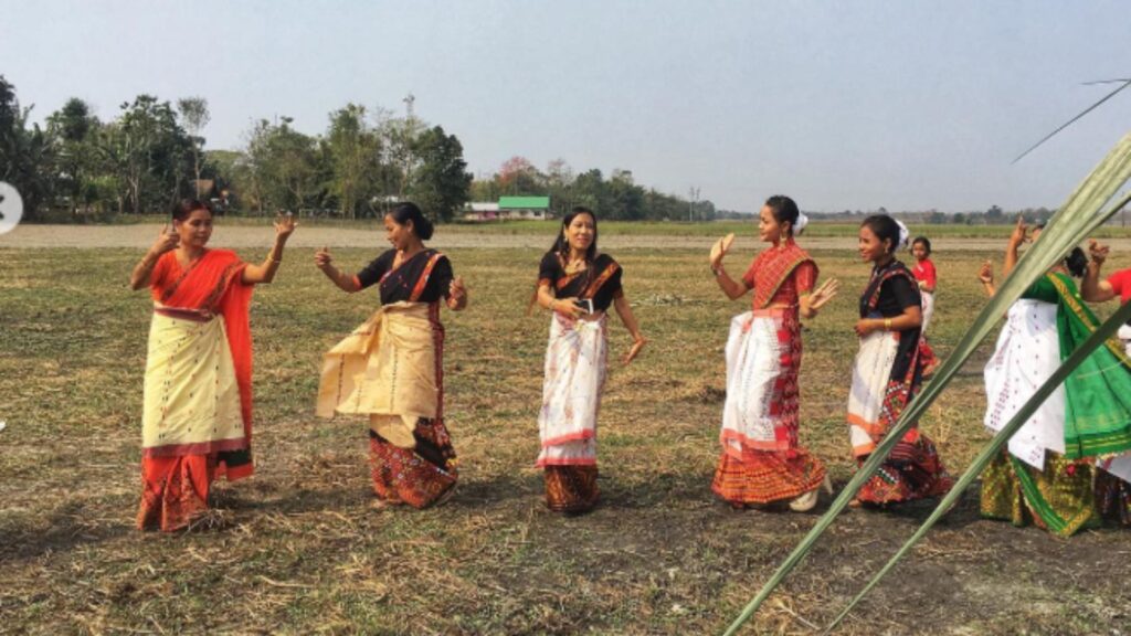 Mising women performing Ali Ai Ligang dance in an open field.