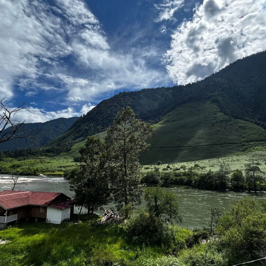 Scenic landscape of Anini with a river flowing past green mountains.