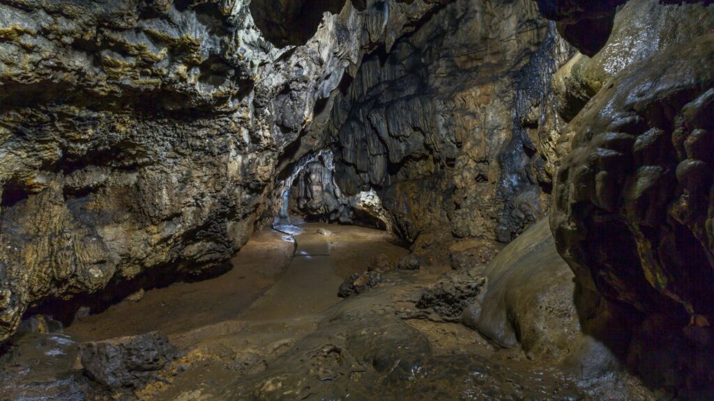 Illuminated cave passage with rock formations