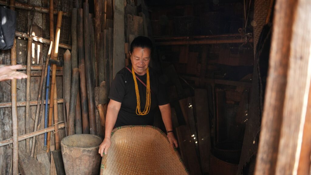 Elder woman displaying handmade bamboo tray.