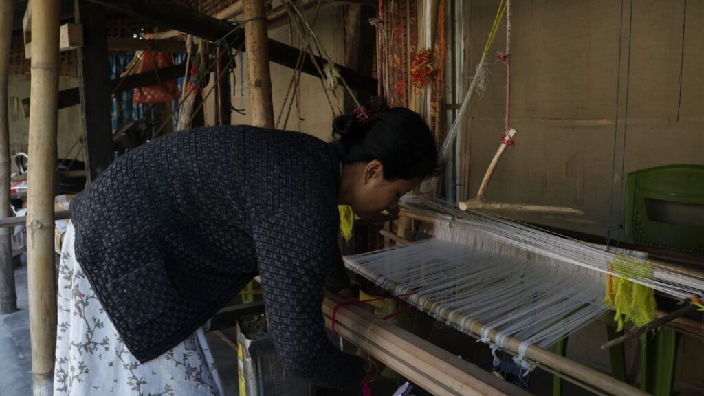Woman working on a loom in Majuli