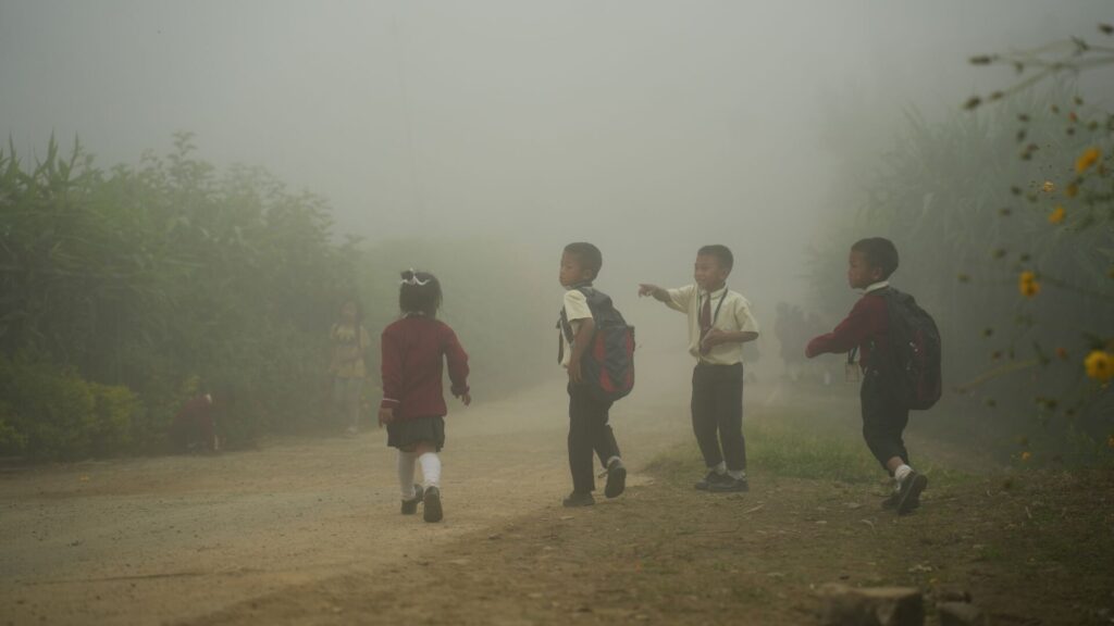 Children walking to school in morning fog