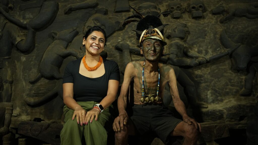 Visitor seated beside tattooed Konyak elder