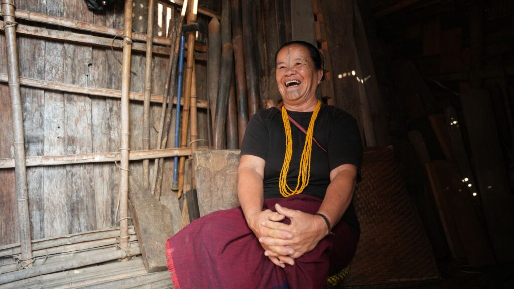 Apatani woman laughing inside bamboo home