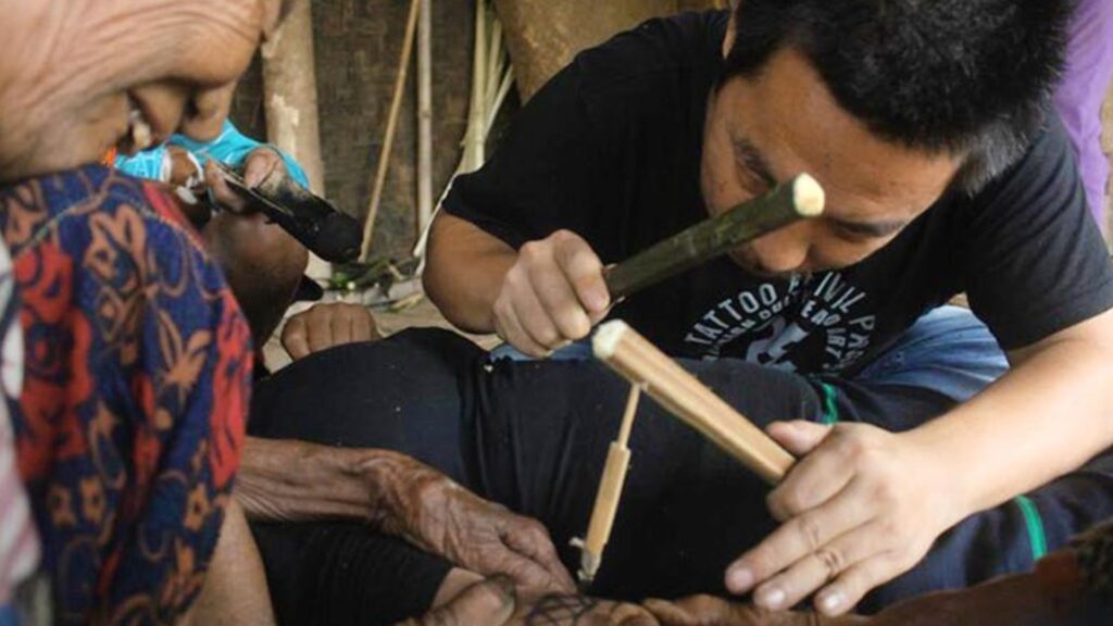 Traditional hand-tapping tattoo process in progress