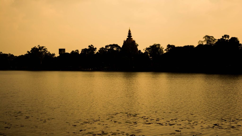 Temple silhouette across water at dusk